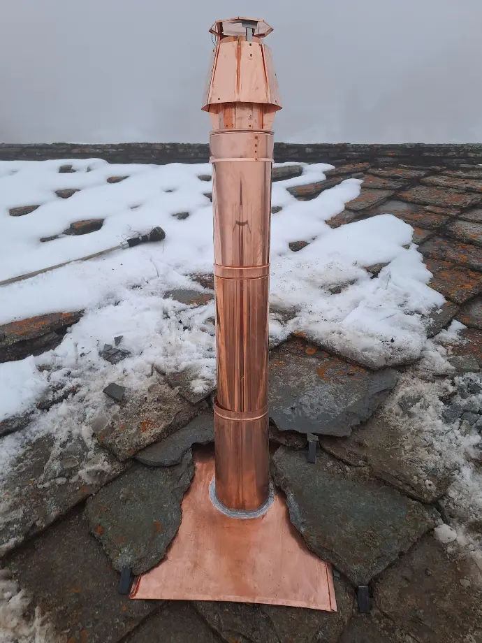 Équipe de couvreurs cordistes professionnels partageant un moment de cohésion sur un chantier en haute montagne. Artisans passionnés en tenue de travail avec équipements de sécurité, illustrant le savoir-faire et la convivialité lors de travaux de toiture complexes en altitude.