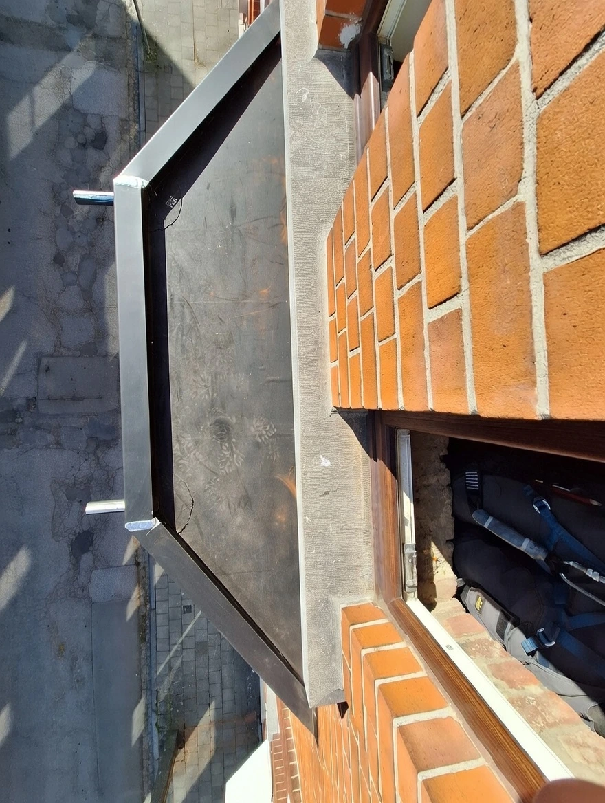 Pose d'un habillage en zinc sur-mesure pour protection de corniche et appui de fenêtre sur une façade en briques. Travail de zinguerie de précision avec soudures étanches et larmiers pour l'évacuation des eaux pluviales, réalisé par un cordiste professionnel